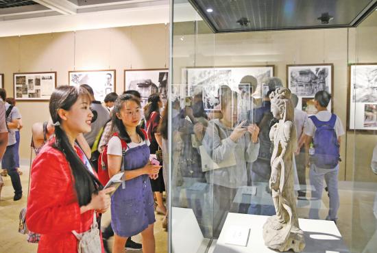 重庆三峡博物馆内，众多市民在观看《回望百年——大足石刻历史影像展》。新渝报记者黄舒摄